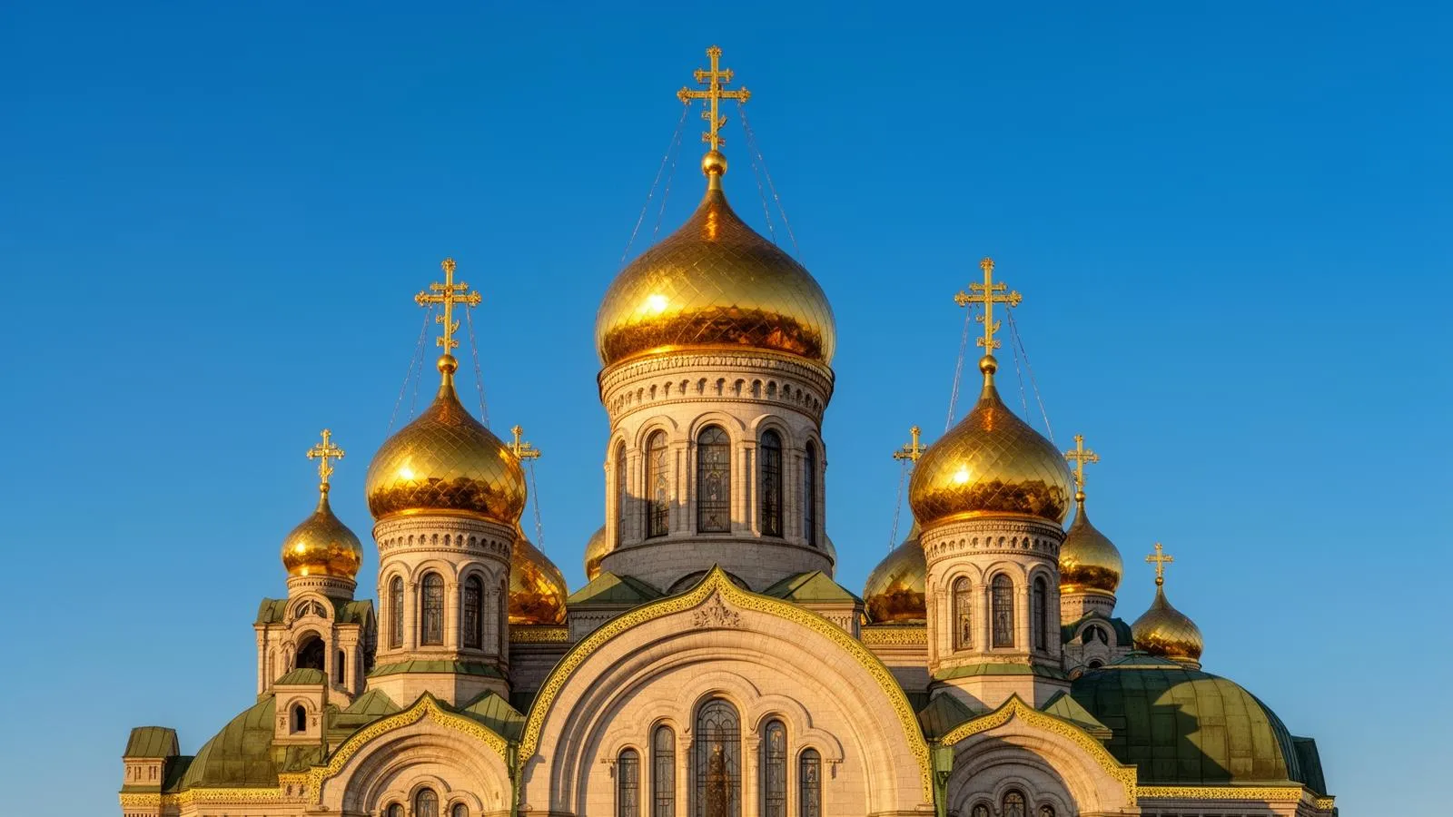 Multiple Orthodox church domes with golden crosses against blue sky